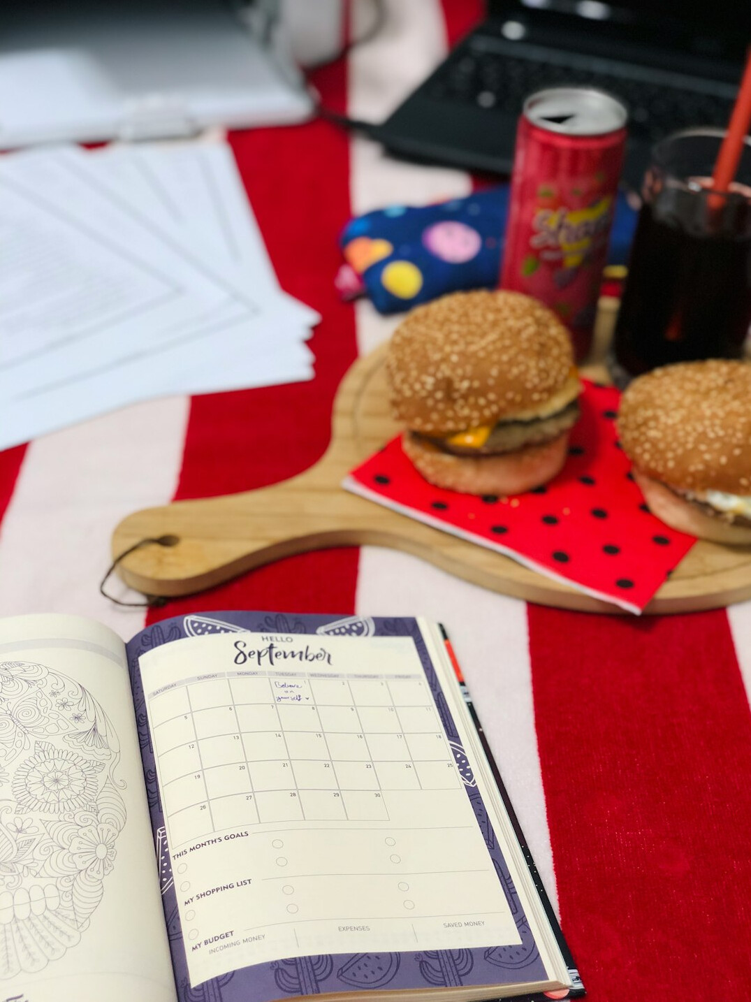 Printed weekly planner and checklist on a wooden table with a pen and cup of coffee